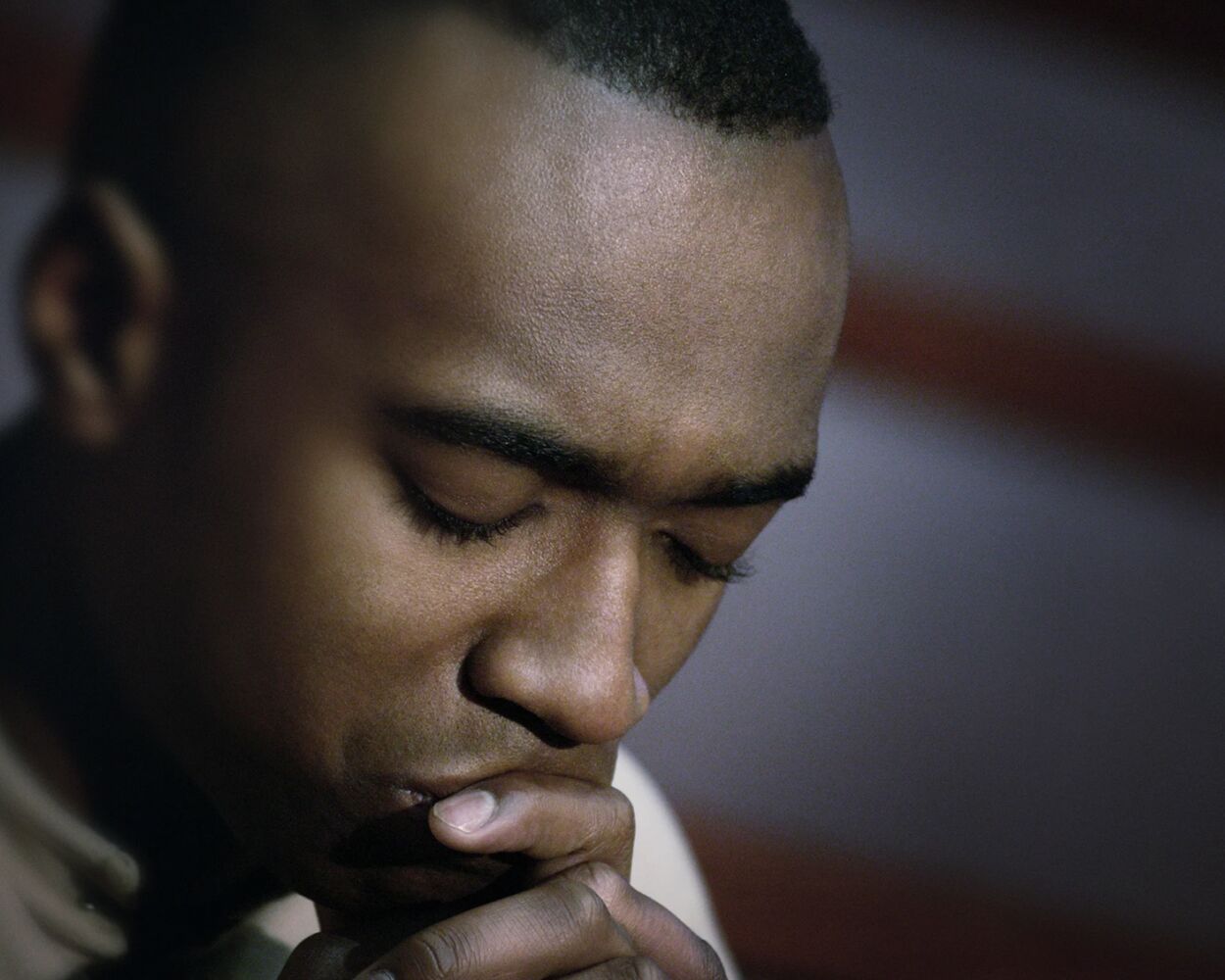 Bisexual man pondering as he thinks about coming out to his family