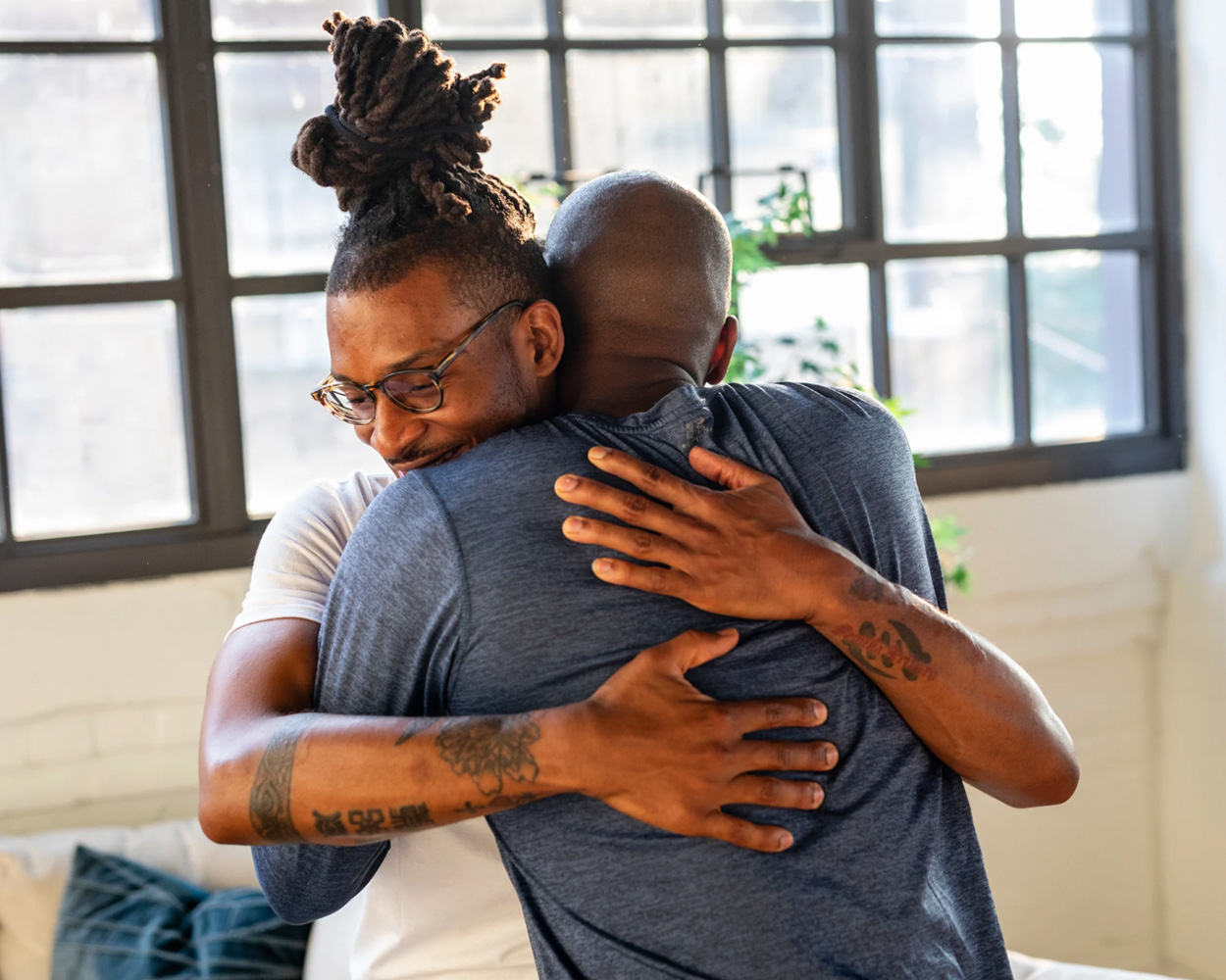 Gay man embracing someone who has helped guide him through tough times